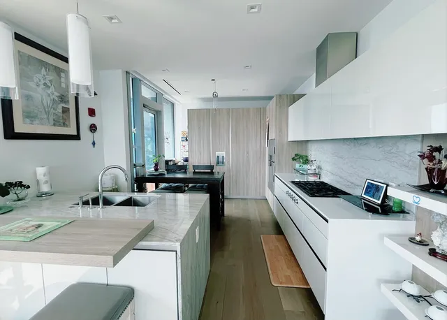 a kitchen with stainless steel appliances a sink a stove top oven a counter space and cabinets