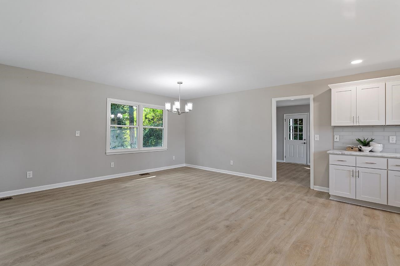 3420 Blue Ridge Road Raleigh, NC 27607 - Photo 13 of 36 wooden floor in an empty room with a window