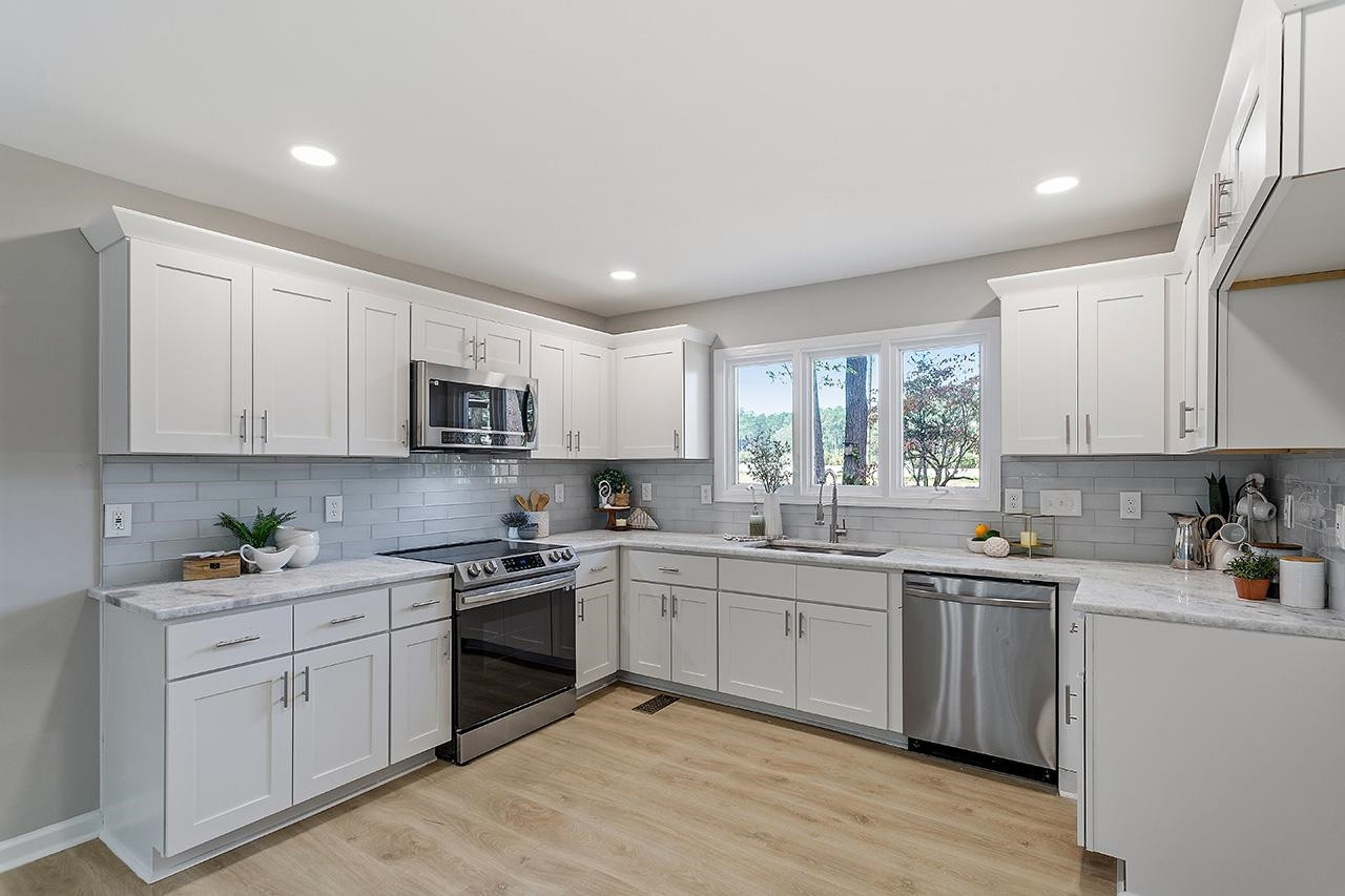 3420 Blue Ridge Road Raleigh, NC 27607 - Photo 2 of 36 a kitchen with a sink white cabinets and white appliances