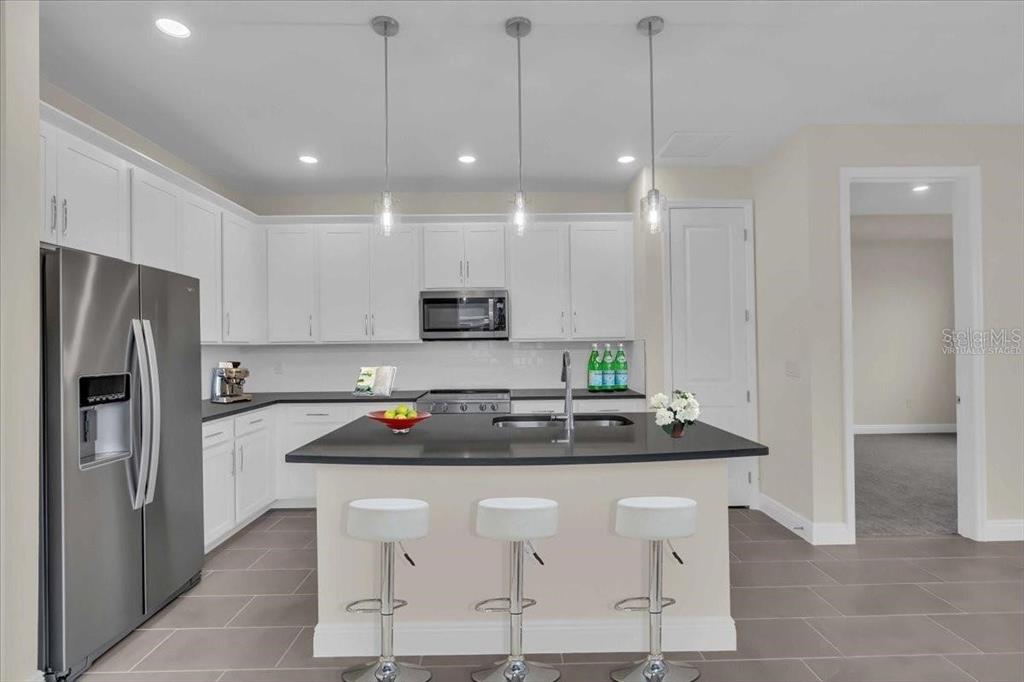 9258 Gulf Haven Drive Palmetto, FL 34221 - Photo 25 of 29 a kitchen with kitchen island a counter top space appliances and cabinets
