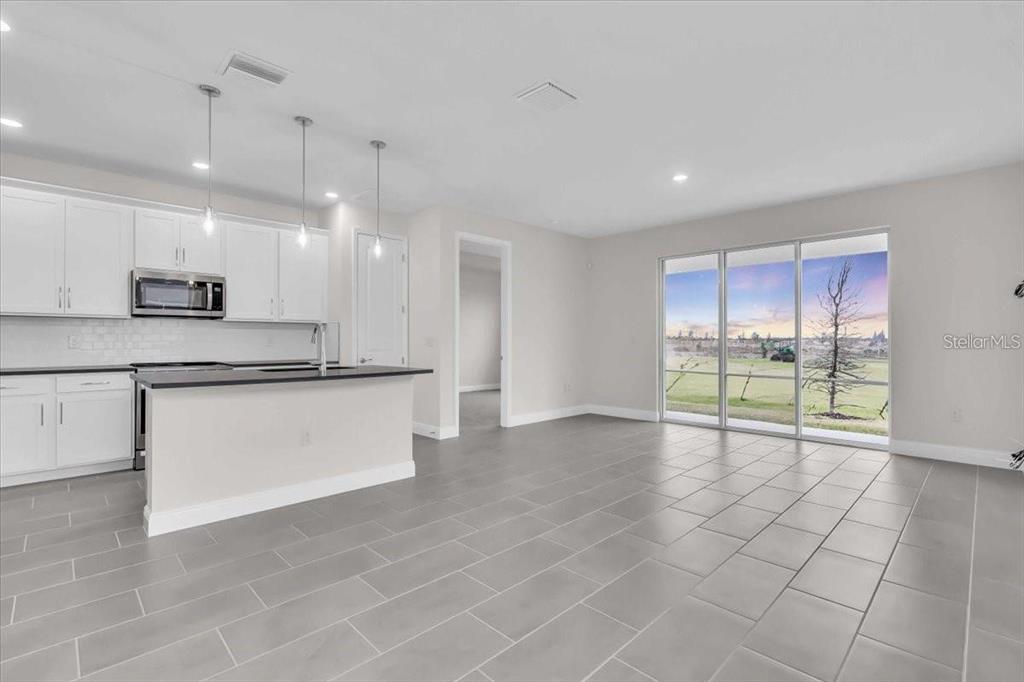 9258 Gulf Haven Drive Palmetto, FL 34221 - Photo 3 of 29 a large kitchen with granite countertop a white floor a large window and a sink