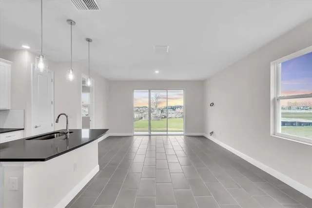 a large kitchen with kitchen island granite countertop a sink a counter top space and cabinets