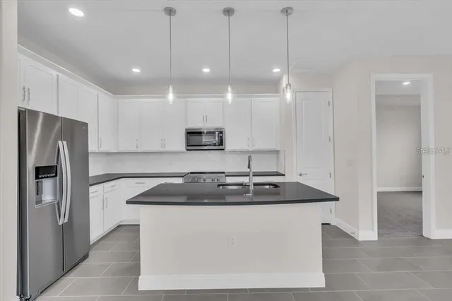 a kitchen with kitchen island a sink stainless steel appliances and cabinets