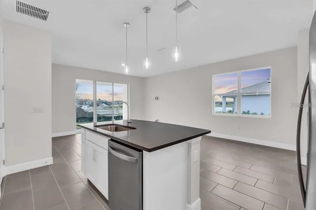 a kitchen with stainless steel appliances granite countertop a sink and a refrigerator
