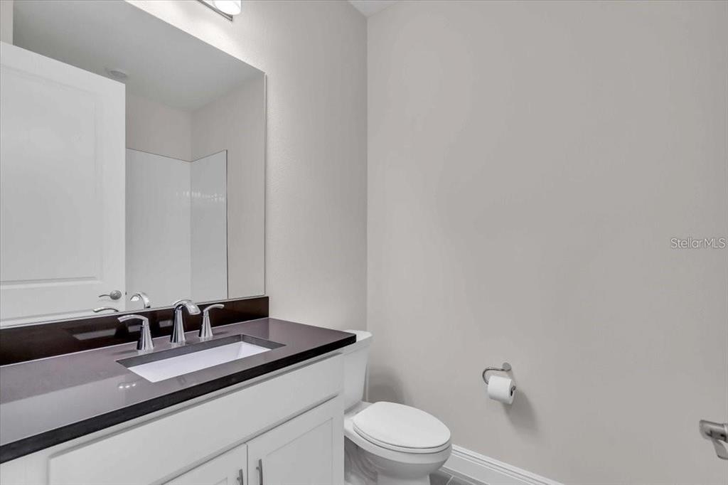 9258 Gulf Haven Drive Palmetto, FL 34221 - Photo 9 of 29 a bathroom with a granite countertop sink a toilet and a mirror