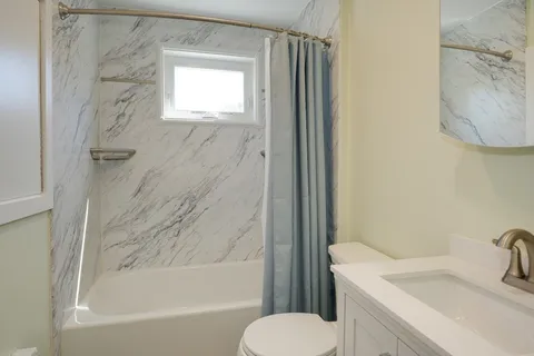 a bathroom with a sink toilet and shower