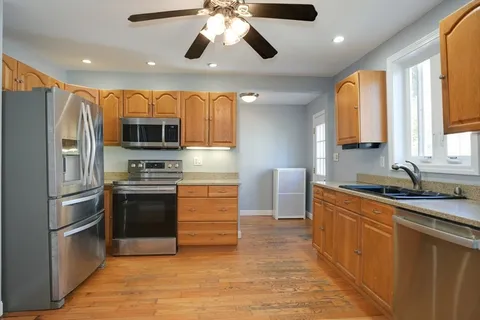a kitchen with stainless steel appliances granite countertop a refrigerator a stove top oven a sink and dishwasher