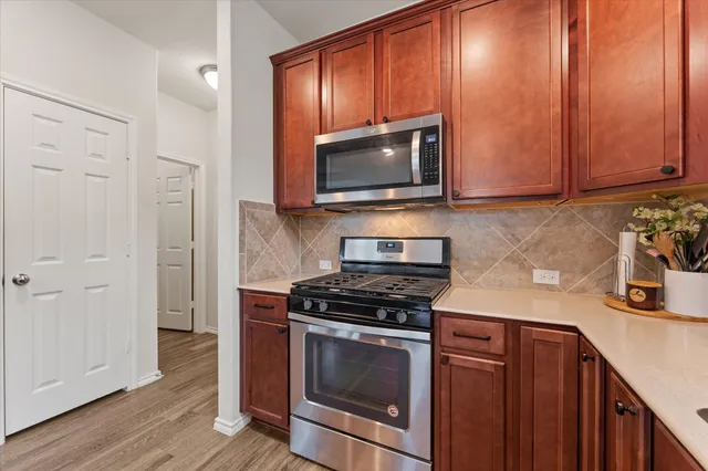 a kitchen with granite countertop cabinets stainless steel appliances and wooden floor