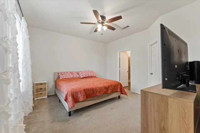 a bedroom with a bed a couch and a chandelier
