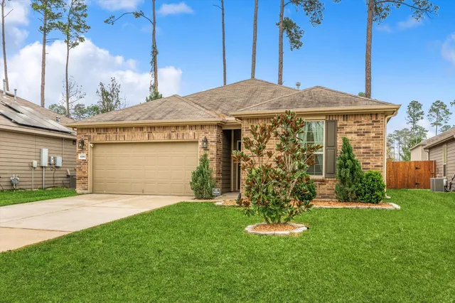 a front view of a house with a garden and yard