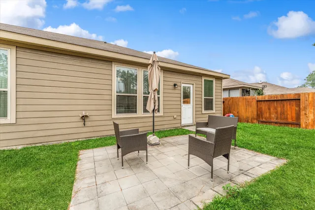 a backyard of a house with a garden and outdoor seating
