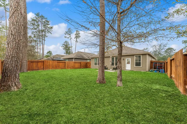 a view of a yard with a house and a large tree