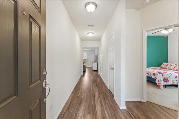 a view of a hallway with wooden floor and closet