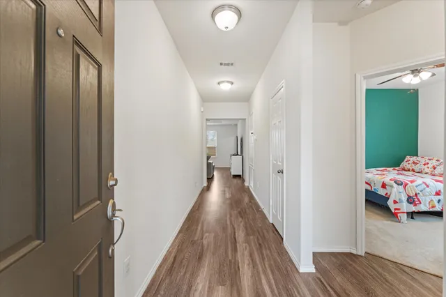 a view of a hallway with wooden floor and closet