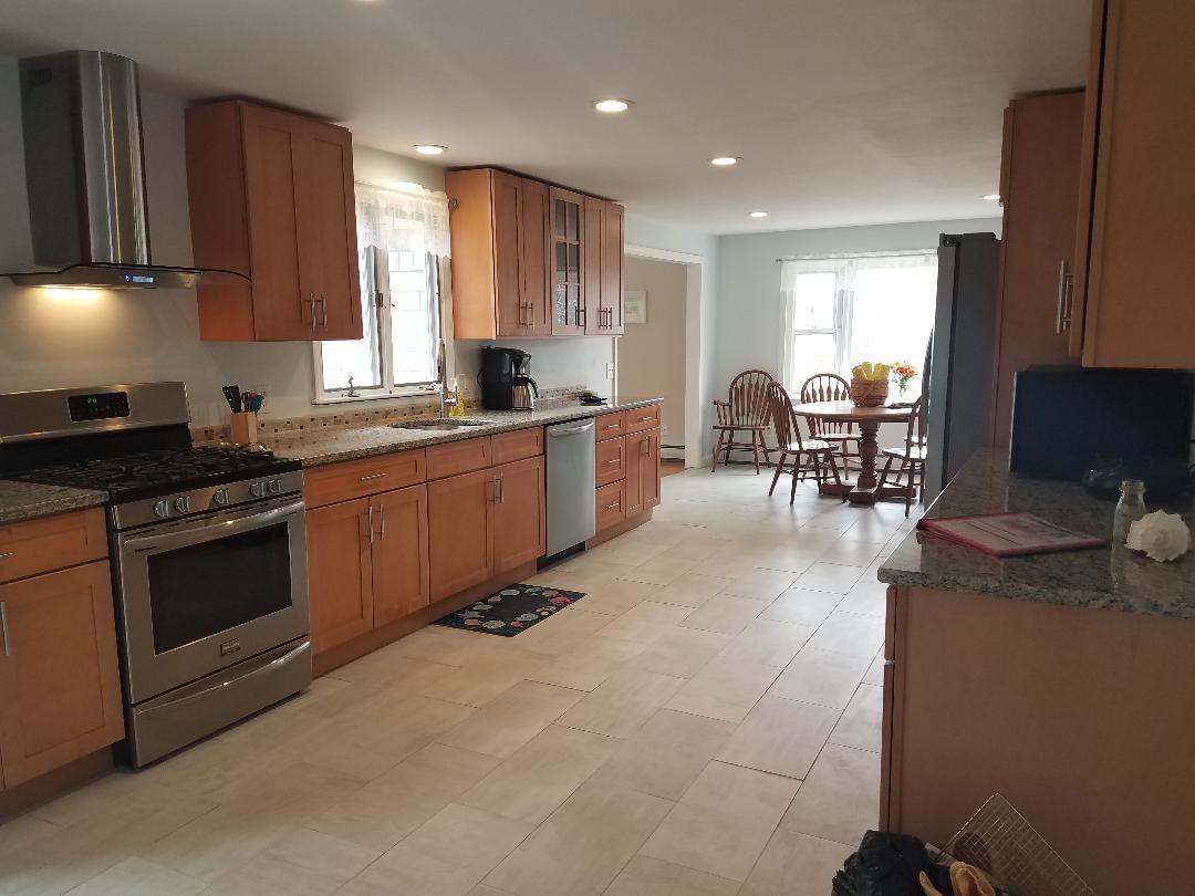 129 Elliott Road Centerville, MA 02632 - Photo 4 of 33 a kitchen with stainless steel appliances granite countertop a stove top oven a sink dishwasher a dining table and chairs with wooden floor