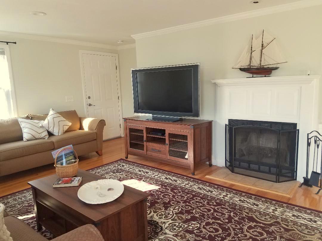 129 Elliott Road Centerville, MA 02632 - Photo 8 of 33 a living room with furniture a flat screen tv and a fireplace