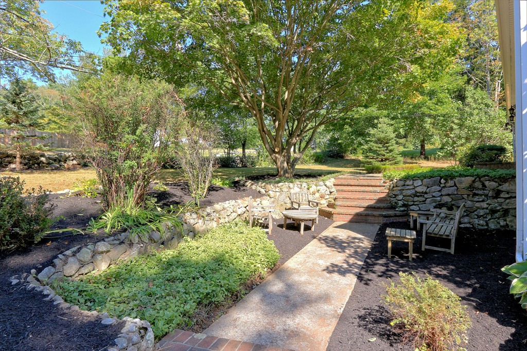 464 Great Road Stow, MA 01775 - Photo 4 of 28 a view of a chair and fire pit in the middle of garden