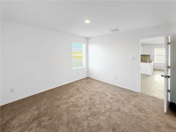 an empty room with a window and wooden floor