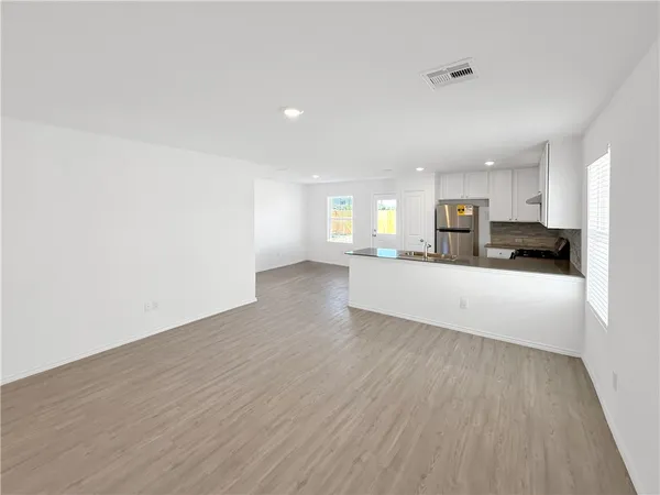 a view of kitchen and hall with wooden floor