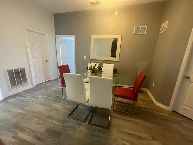 a dining room with furniture and wooden floor