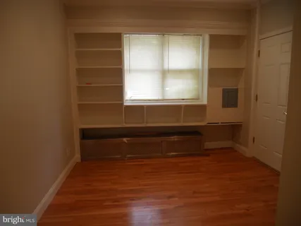 a view of a small space with wooden floor and a window