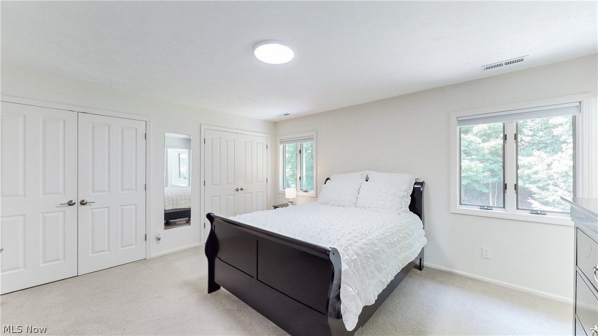 3700 Chagrin River Road Chagrin Falls, OH 44022 - Photo 27 of 43 Bedroom 3 featuring light carpet, multiple closets, and multiple windows
