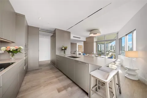 a large white kitchen with a table and chairs