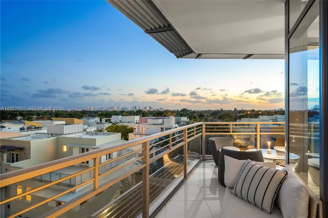 a view of a balcony with couches wooden floor and city view