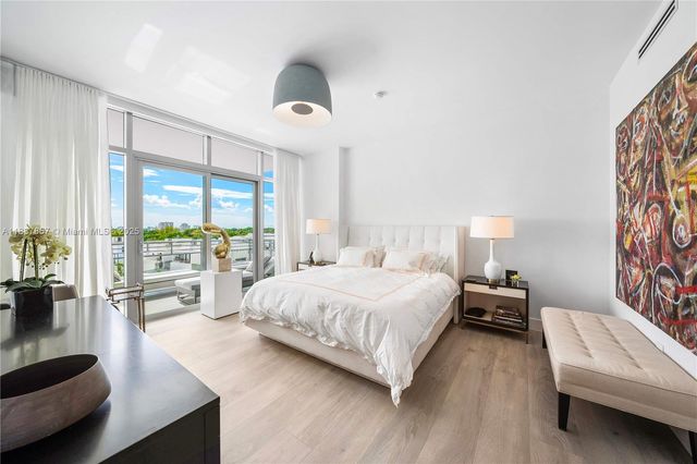 a spacious bedroom with a bed and a large window