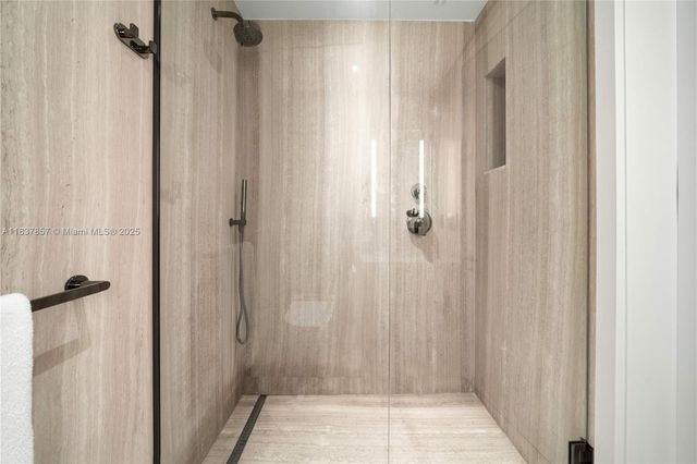 a bathroom with a shower and a glass door