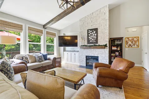 a living room with furniture chandelier and a large window