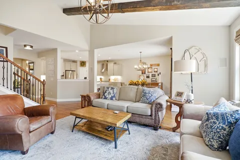 a dining room filled chandelier and kitchen view