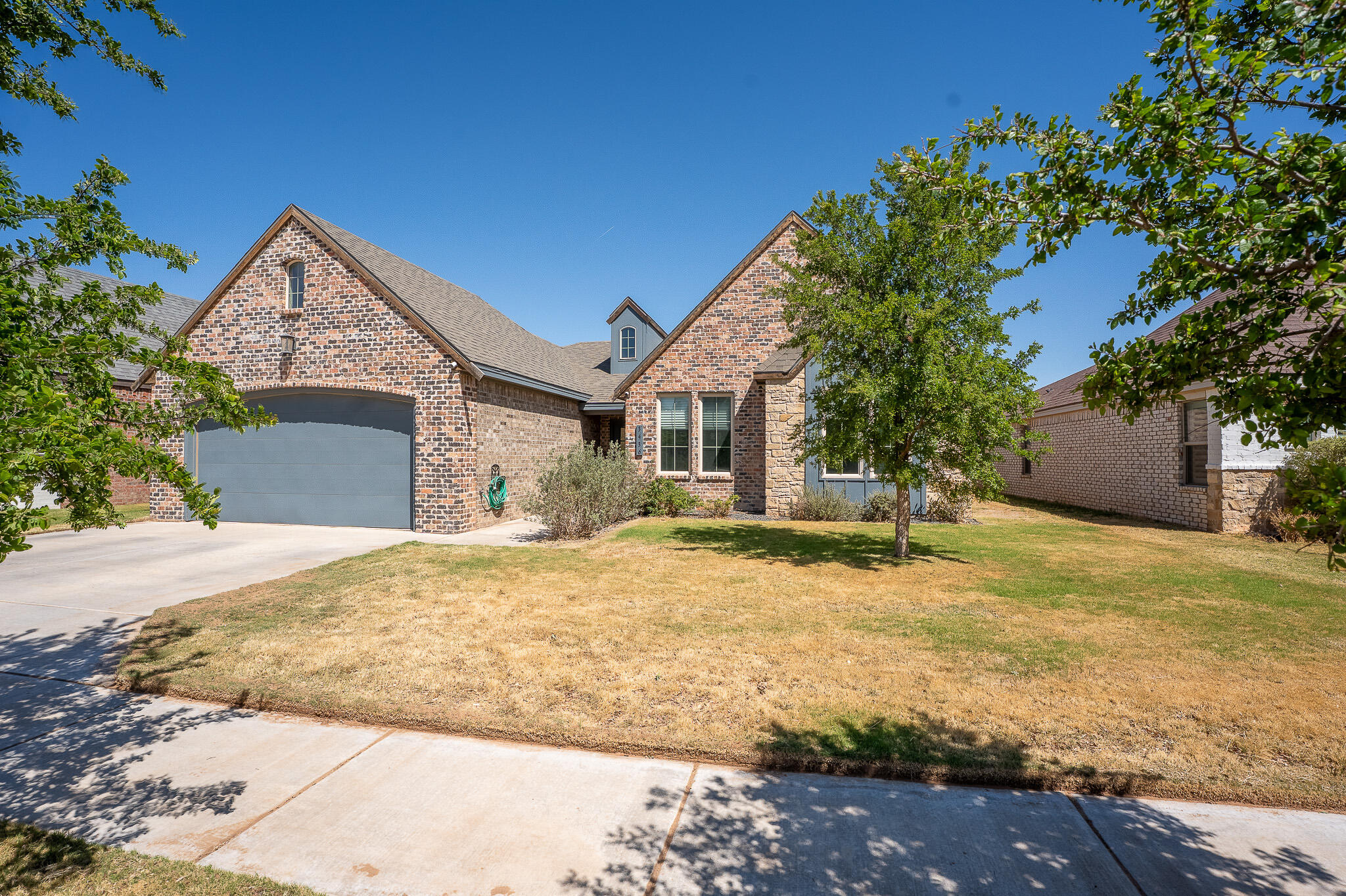 3436 125th Street Lubbock, TX 79423 - Photo 18 of 22 a front view of a house with a yard and garage