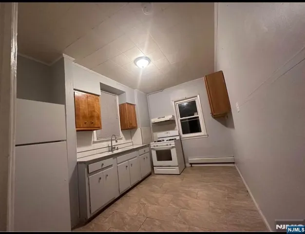 a kitchen with cabinets and wooden floor
