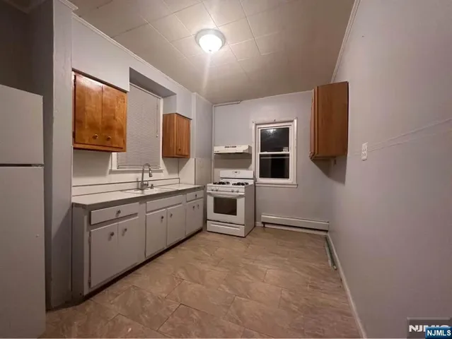 a large white room with stainless steel appliances