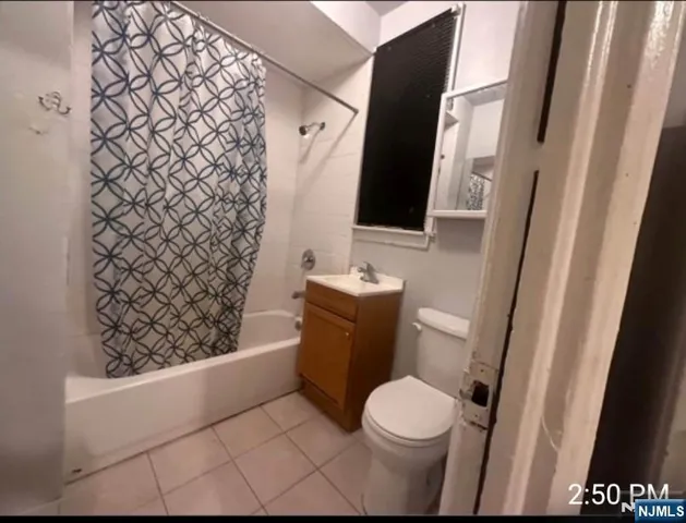 a bathroom with a toilet and a shower curtain