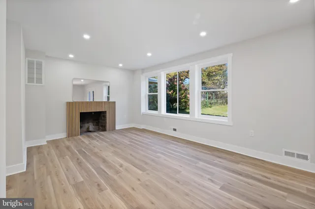 a view of an empty room with a fireplace and a window