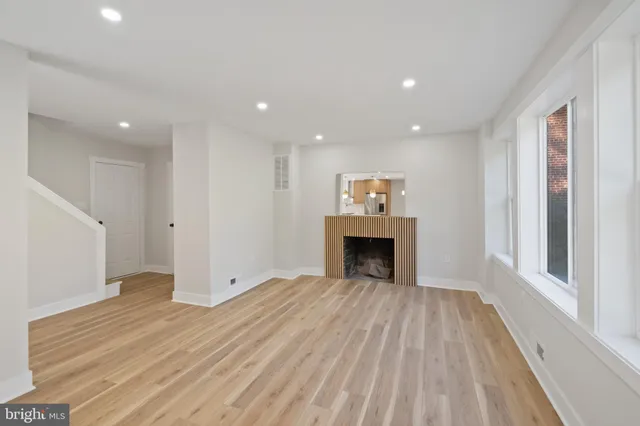 a view of empty room with wooden floor and fireplace