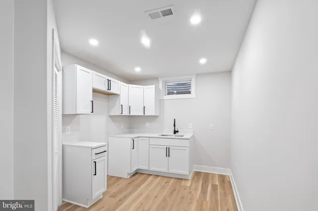 a kitchen with a sink cabinets stainless steel appliances and a window