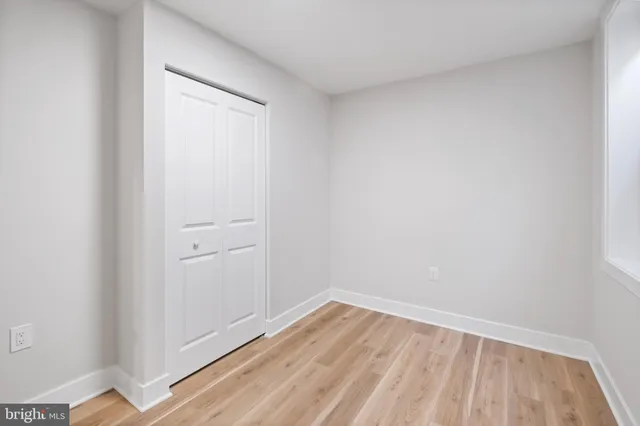a view of a room with wooden floor and a window