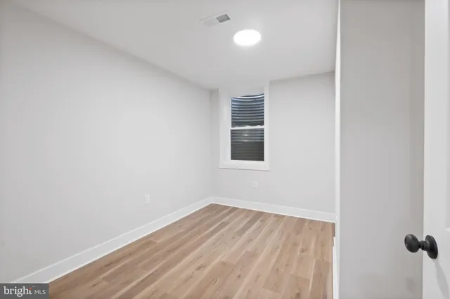 a view of a room that has wooden floor and a window