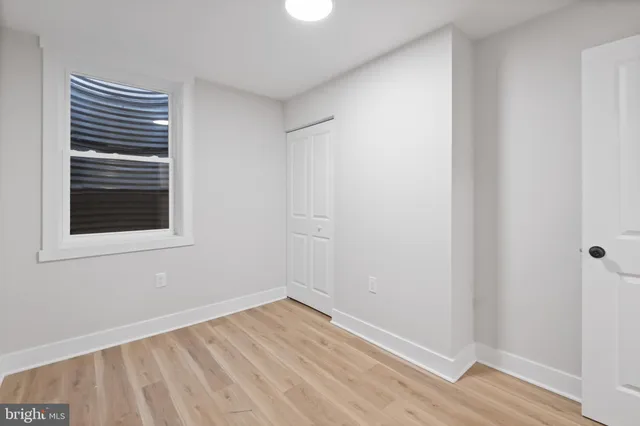 a view of a room with wooden floor chandeliers and kitchen view