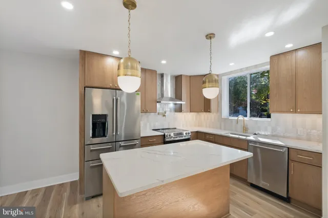 a kitchen with a sink a counter top space stainless steel appliances and cabinets