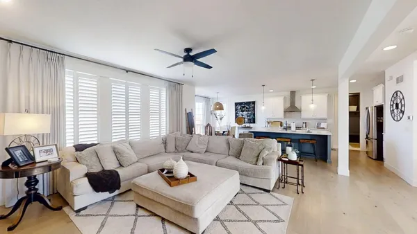 a living room with furniture and a view of kitchen