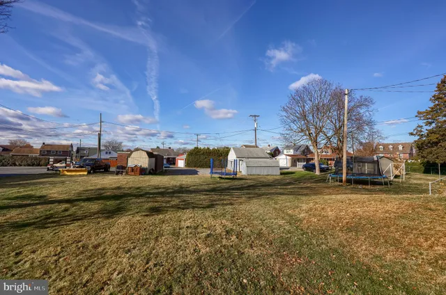 a view of a big house with a big yard and large trees