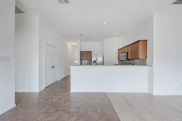 a view of kitchen with kitchen island microwave and refrigerator