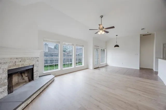 wooden floor fireplace and windows in an empty room