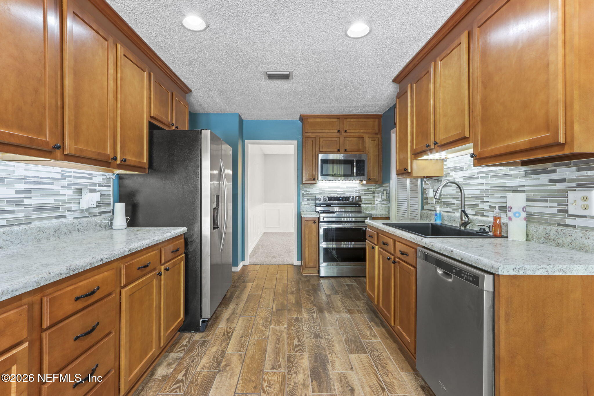 120 Vanderford Road North Orange Park, FL 32073 - Photo 6 of 40 a kitchen with granite countertop a sink cabinets stainless steel appliances and a counter top space