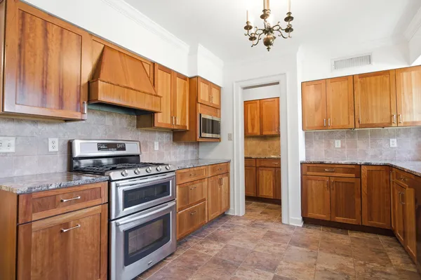 a kitchen with stainless steel appliances granite countertop a refrigerator a sink dishwasher a stove and a refrigerator with wooden floor