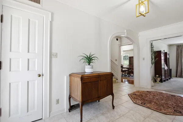 a hallway with wooden floor and a bathroom